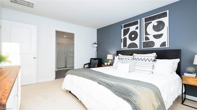 bedroom featuring a spacious closet, light carpet, and a closet