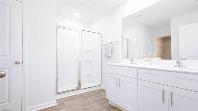 bathroom with hardwood / wood-style floors, vanity, and an enclosed shower