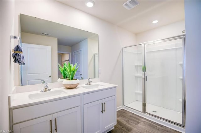 bathroom with a shower with door, vanity, and wood-type flooring