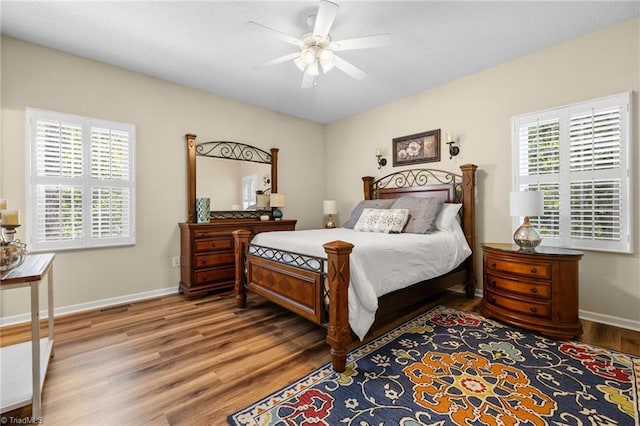 bedroom with ceiling fan, hardwood / wood-style flooring, and multiple windows