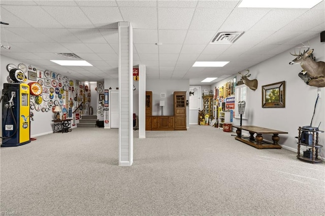 interior space featuring light carpet and a paneled ceiling