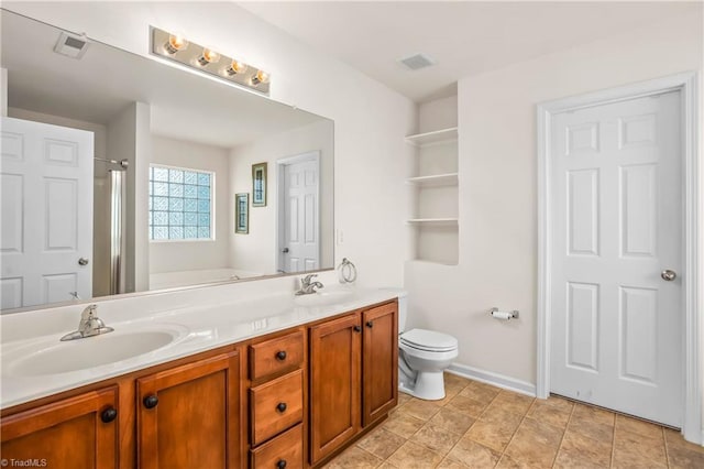 full bath featuring toilet, double vanity, a sink, and visible vents