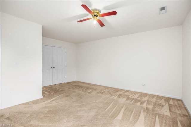 carpeted empty room with ceiling fan, baseboards, and visible vents