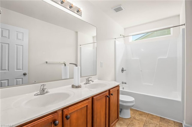 bathroom with visible vents, toilet, double vanity, and a sink