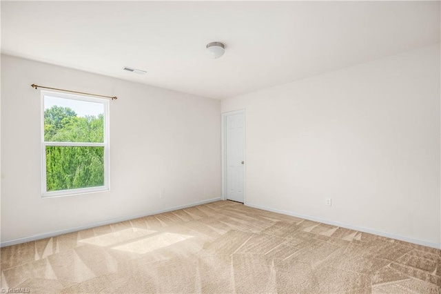 unfurnished room with light colored carpet, visible vents, and baseboards