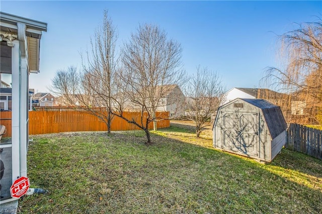 view of yard with an outbuilding, a storage unit, and a fenced backyard