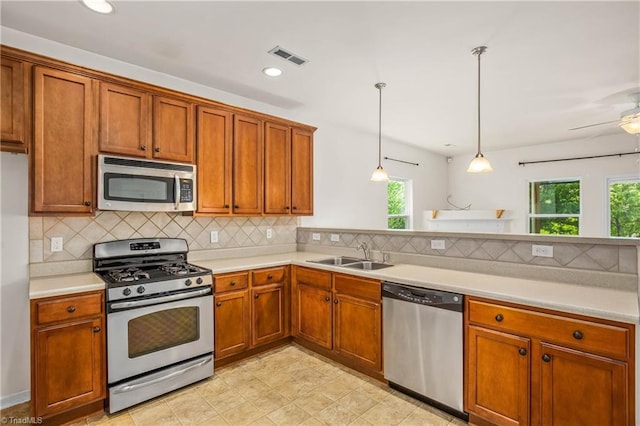 kitchen with a sink, a healthy amount of sunlight, stainless steel appliances, and light countertops
