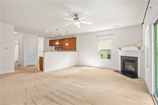 unfurnished living room featuring a fireplace with flush hearth, ceiling fan, recessed lighting, and light carpet