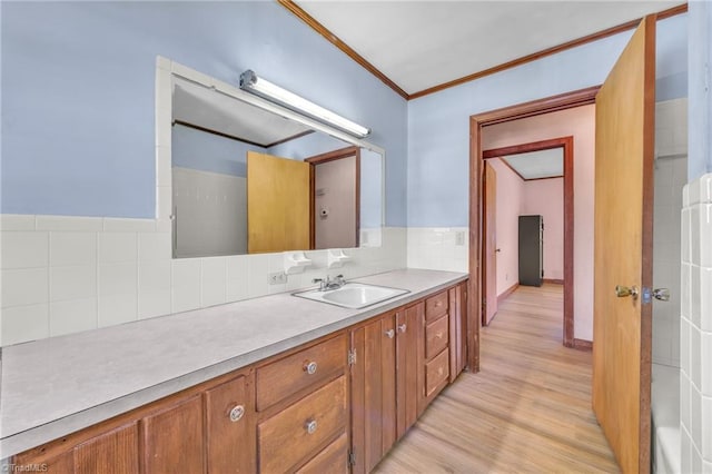 bathroom featuring backsplash, wood finished floors, vanity, and crown molding