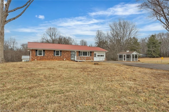 ranch-style house featuring a garage, brick siding, a porch, and aphalt driveway