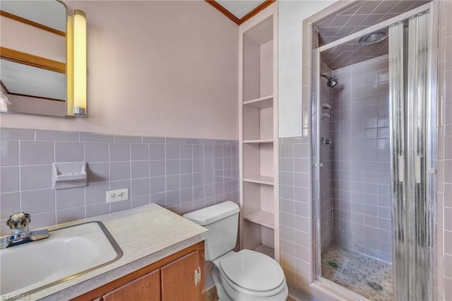 full bath featuring toilet, a wainscoted wall, vanity, a shower stall, and tile walls