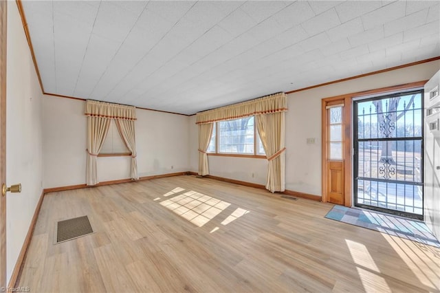 foyer with light wood finished floors, visible vents, and crown molding