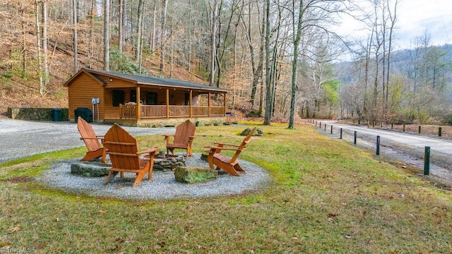 view of yard featuring gravel driveway and a view of trees