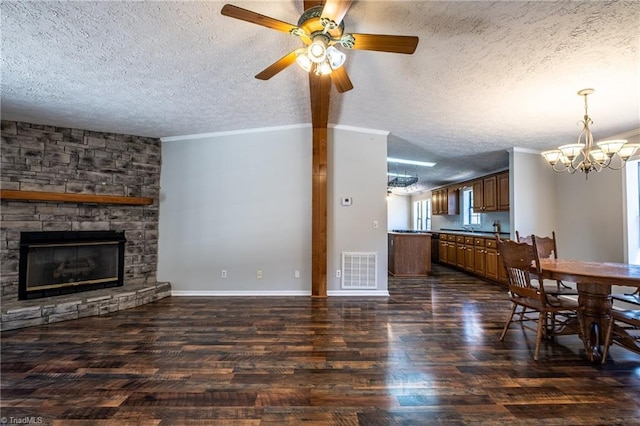 living room with a stone fireplace, visible vents, dark wood-style flooring, and a textured ceiling