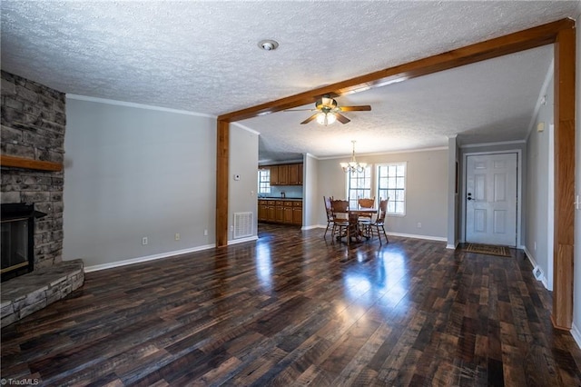 living area featuring visible vents, a textured ceiling, dark wood finished floors, a fireplace, and crown molding