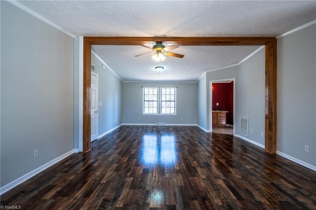 spare room featuring dark wood finished floors, visible vents, a textured ceiling, and ornamental molding