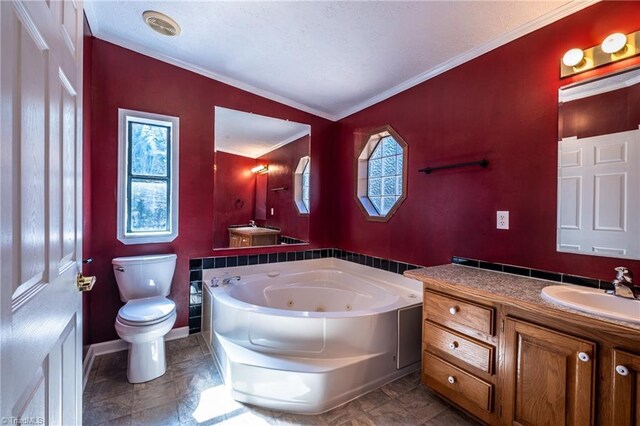 bathroom featuring toilet, a jetted tub, crown molding, a healthy amount of sunlight, and vanity