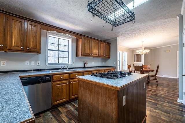 kitchen featuring a center island, dark wood finished floors, dishwasher, gas cooktop, and a sink