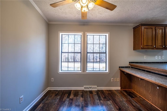 unfurnished dining area featuring dark wood-style floors, visible vents, and a wealth of natural light