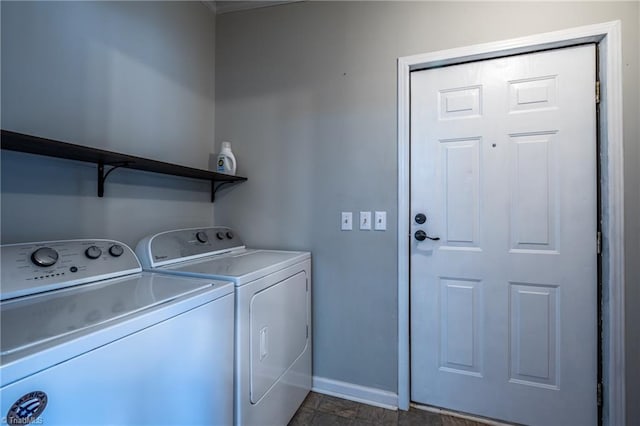 laundry area with laundry area, washing machine and dryer, and baseboards