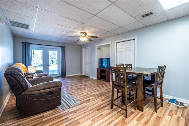 dining room featuring baseboards, french doors, visible vents, and light wood-type flooring