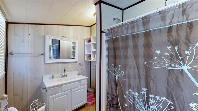 bathroom featuring wood walls, curtained shower, crown molding, and vanity