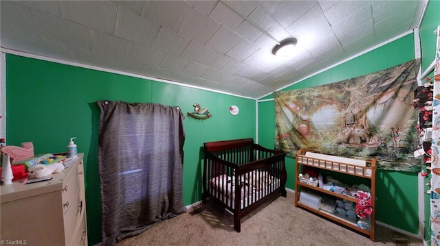 carpeted bedroom featuring a crib and vaulted ceiling