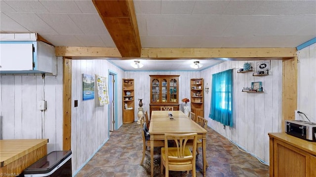 dining space featuring wood walls