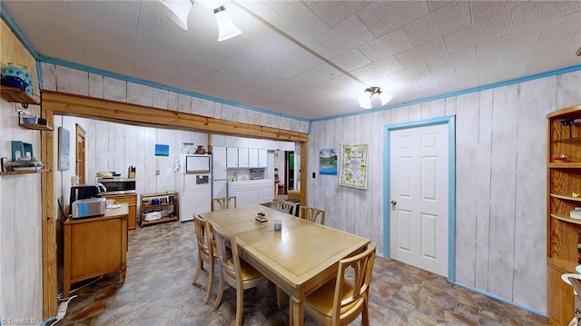 dining space featuring wood walls