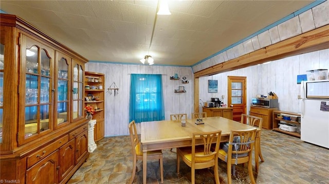 dining area with wooden walls and crown molding