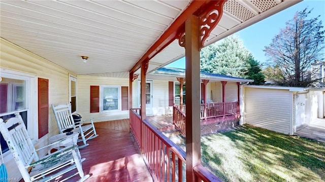 wooden terrace with a yard and covered porch