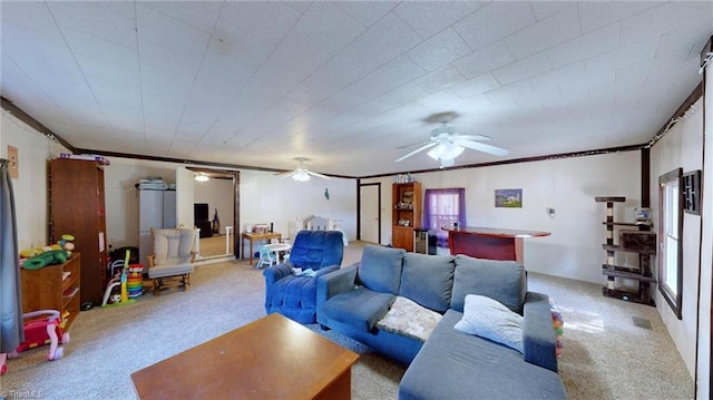 carpeted living room with crown molding, ceiling fan, and indoor bar