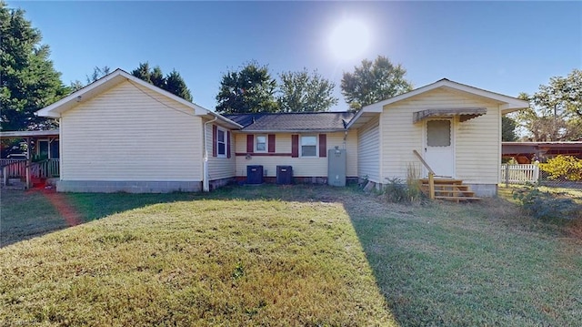 back of property featuring a yard and central AC