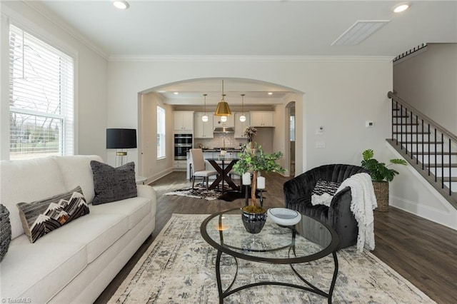 living area featuring stairs, crown molding, and dark wood-style flooring