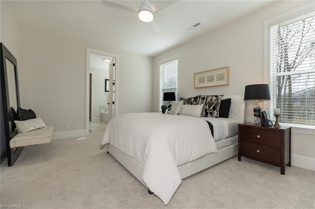 bedroom featuring visible vents, multiple windows, light colored carpet, and baseboards