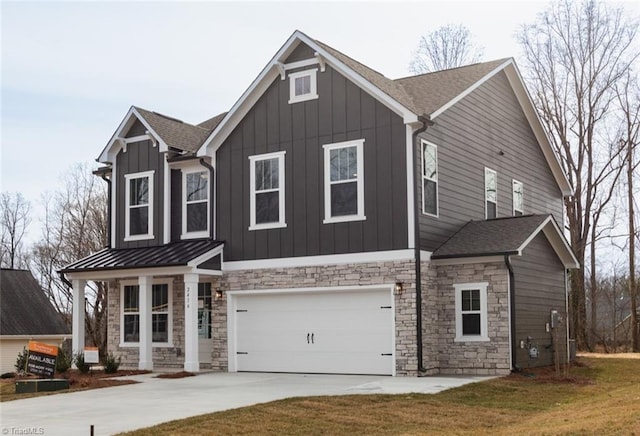 view of front of home with a standing seam roof, an attached garage, concrete driveway, board and batten siding, and metal roof