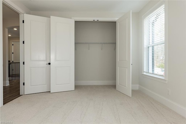 unfurnished bedroom featuring a closet, baseboards, and carpet