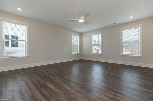 spare room with dark wood-type flooring, recessed lighting, a ceiling fan, and baseboards