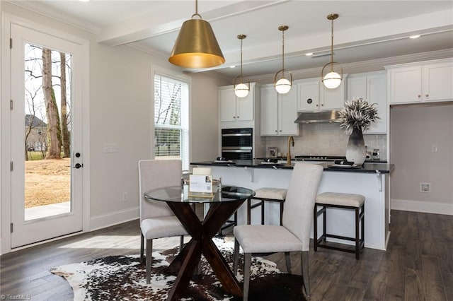 dining area featuring dark wood finished floors, crown molding, beamed ceiling, and baseboards