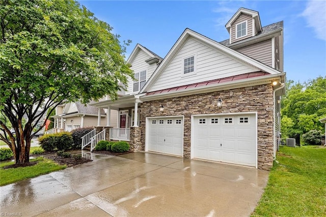 2067 Glenkirk Dr, Burlington, NC 27215 - view of front facade with stone siding, concrete driveway, a standing seam roof, central air condition unit, and a front lawn