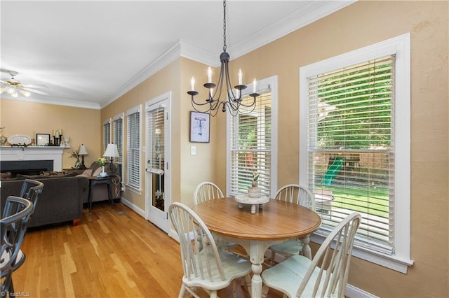 137 Bradford Place Ln, Lewisville, NC 27023 - dining area featuring a chandelier, light wood-style flooring, crown molding, a ceiling fan, and a fireplace