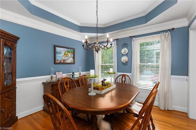 137 Bradford Place Ln, Lewisville, NC 27023 - dining area with a chandelier, a wainscoted wall, light wood-style flooring, crown molding, and a raised ceiling