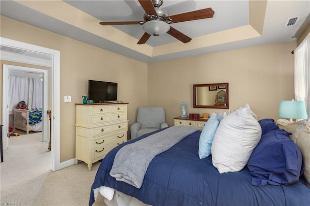 137 Bradford Place Ln, Lewisville, NC 27023 - bedroom with light colored carpet, a tray ceiling, and a ceiling fan