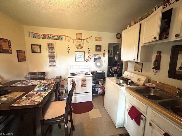 717 Dale St, Greensboro, NC 27406 - kitchen with white electric range, washer / dryer, white cabinets, a sink, and a textured ceiling