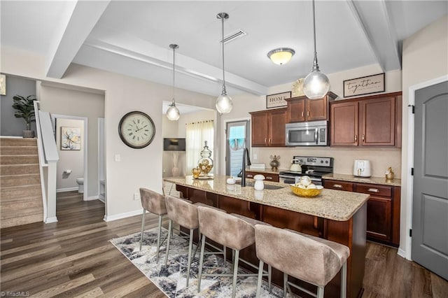 kitchen with a kitchen bar, beam ceiling, stainless steel appliances, and decorative light fixtures