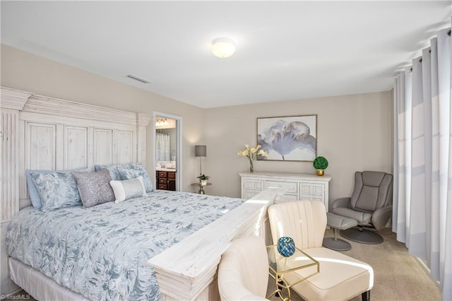 bedroom featuring light carpet and ensuite bathroom