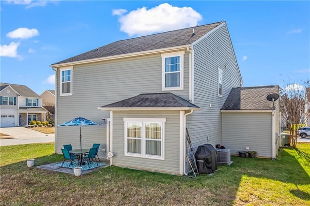 back of property with a lawn, central air condition unit, and a patio