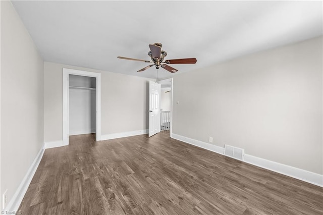 unfurnished bedroom with a closet, ceiling fan, and dark wood-type flooring