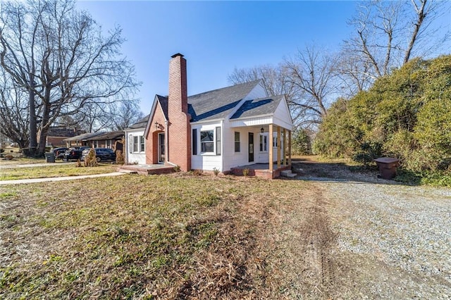 view of side of home with a yard and a porch