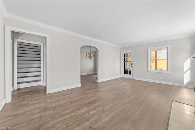 unfurnished living room with ornamental molding, hardwood / wood-style flooring, and a notable chandelier